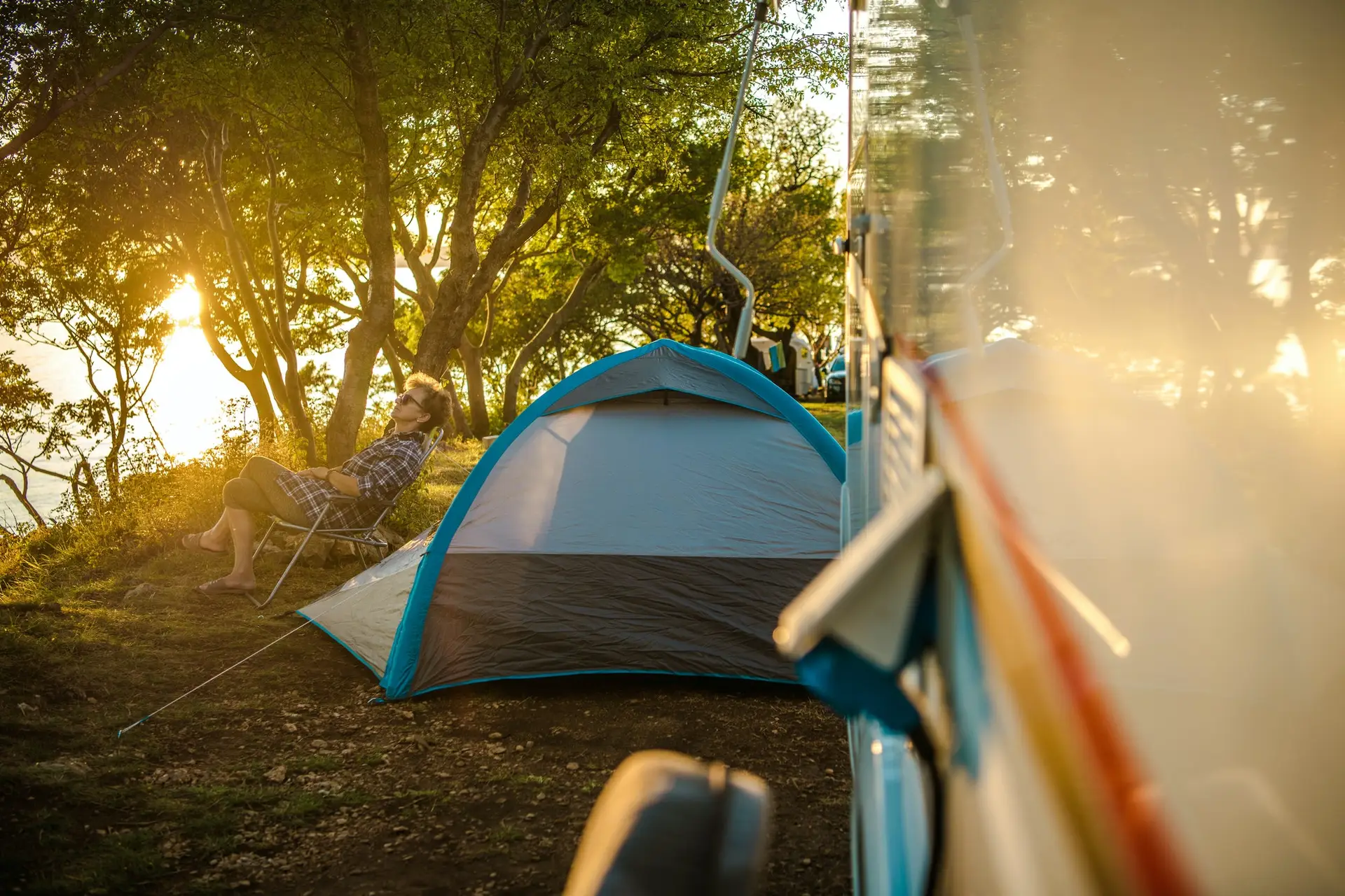 Woman Relaxing At Campsite Near RV.